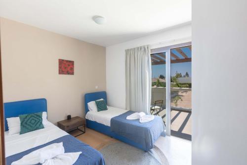 a bedroom with two beds and a balcony at Napa Sunlight Villa #2 in Ayia Napa