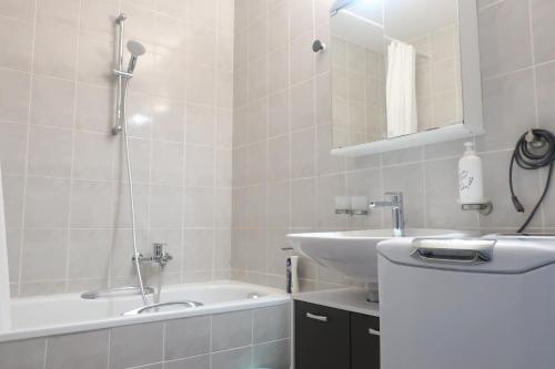 ein Badezimmer mit Badewanne, Waschbecken und Badewanne Tubermottermott in der Unterkunft C A L M au Cœur du Valais in Riddes