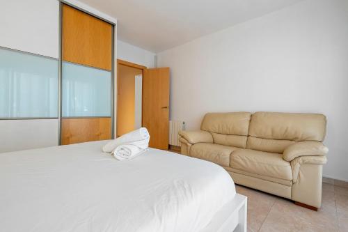 a bedroom with a bed and a couch at Center Beach Calafell in Calafell