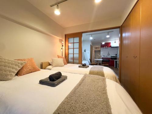 ein Schlafzimmer mit 2 Betten und Handtüchern darauf in der Unterkunft 渋谷Eアドレス in Tokio