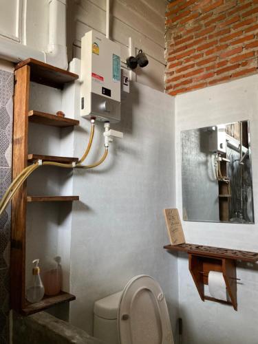 a small bathroom with a toilet and a mirror at Banban Nannan Library and Guesthome in Nan