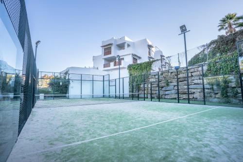 een tennisbaan voor een huis bij Moderno apartamento de dos dormitorios al lado del Golf in Estepona
