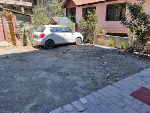 une voiture blanche garée devant une maison dans l'établissement Neo Loyal Villa, à Manali