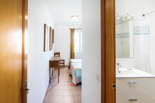 La salle de bains est pourvue d'un lavabo, d'une table et d'un lit. dans l'établissement Villa Terra, à Son Bou