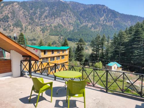 d'une table et de chaises sur un balcon avec vue sur la montagne. dans l'établissement Neo Loyal Villa, à Manali