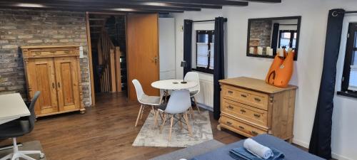 een kamer met een tafel en stoelen en een gitaar bij altes romantisches Fachwerkhaus in Rheinnähe auch für Workation geeignet in Keulen