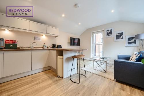 a kitchen and a living room with a couch at Festival Serviced Apartment, Perfect of Contractors & Families FREE Wifi & Netflix By REDWOOD STAYS in Basingstoke