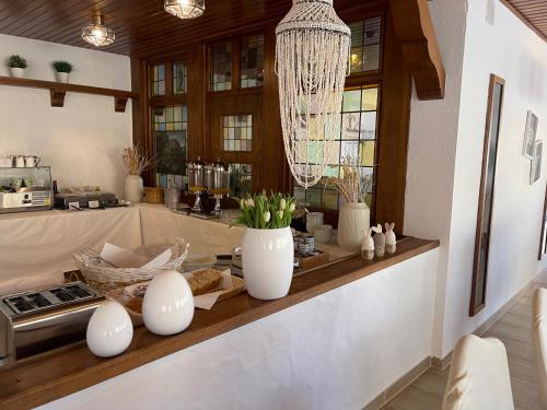 a kitchen with a counter with vases and a chandelier at Hotel "Zur schönen Aussicht" in Cochem