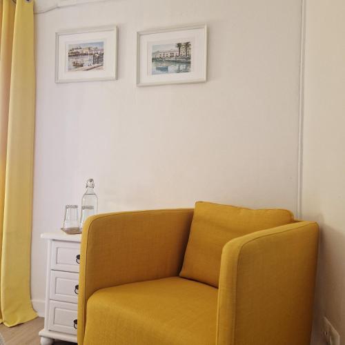 a yellow chair sitting next to a white cabinet at Bea's Bed & Breakfast in Tavira