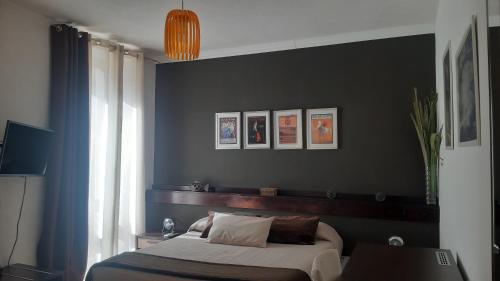 敘拉古的住宿－Casa Antioco B&B，一间卧室设有一张床和黑色的墙壁