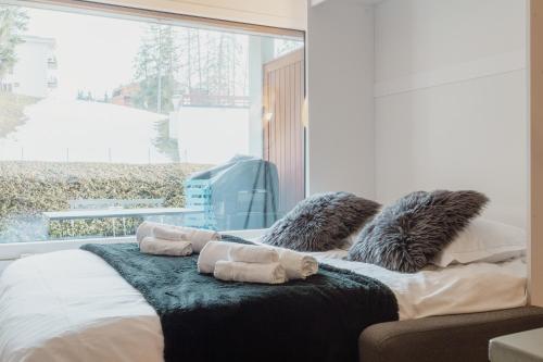 1 dormitorio con 1 cama y ventana grande en Studio rénové et élégant en plein centre en Crans-Montana