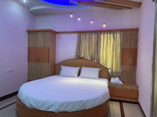 a bedroom with a large bed and a window at Aesthetic, beautiful & Furnished in Bellary