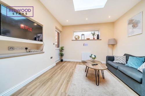 a living room with a couch and a tv at Festival Place, Town Center Serviced Apartments, Perfect of Contractors & Families FREE Wifi & Netflix By REDWOOD STAYS in Basingstoke