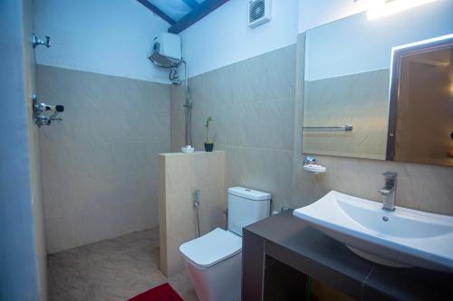 a bathroom with a white toilet and a sink at 209 Nooit Gedacht in Unawatuna