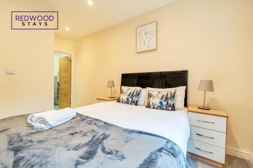 a bedroom with a large white bed and a dresser at Festival Serviced Apartment, Perfect of Contractors & Families FREE Wifi & Netflix By REDWOOD STAYS in Basingstoke