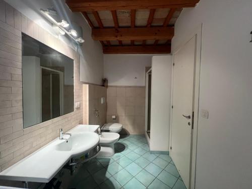 ein Badezimmer mit 2 WCs, einem Waschbecken und einem Spiegel in der Unterkunft vista sul corso in Iesi