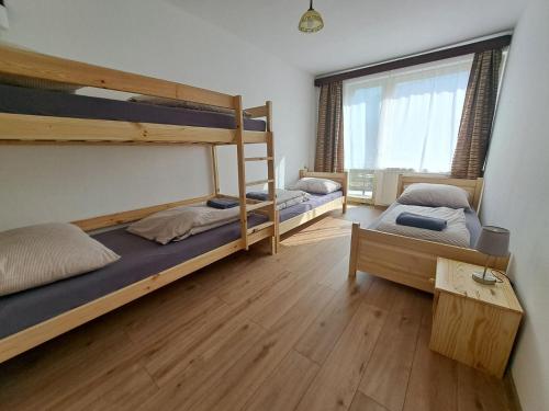 two bunk beds in a room with a window at Dom horskej služby in Terchová