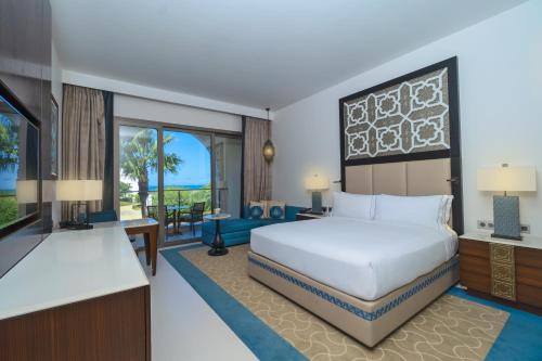 a hotel room with a bed and a television at Hilton Tangier Al Houara Resort & Spa in Al Houara