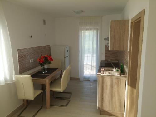 cocina con mesa de madera y cocina con comedor en Apartments Rtina Benici, en Rtina