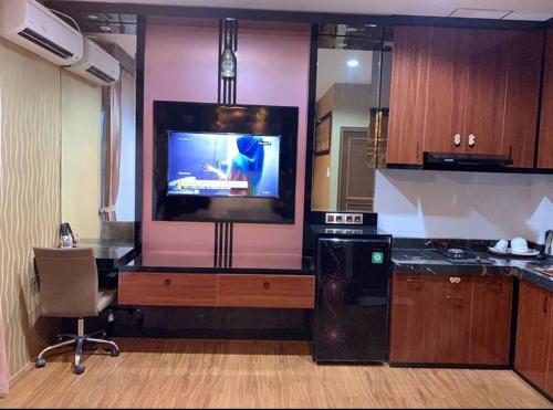 een keuken met een flatscreen-tv in een kamer bij Syndicet Apartemen in Wirolegi