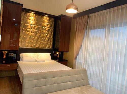 een slaapkamer met een bed en een groot raam bij Syndicet Apartemen in Wirolegi