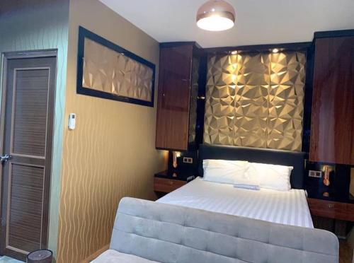 1 dormitorio con 1 cama con cabecero grande en Syndicet Apartemen en Wirolegi