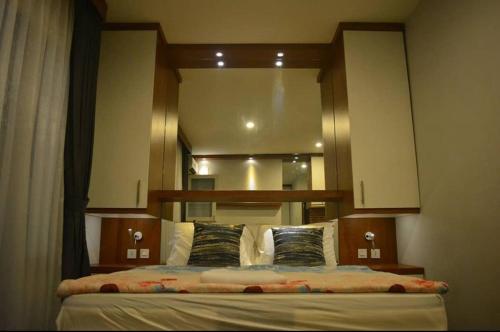 een slaapkamer met een grote spiegel boven een bed bij Syndicet Apartemen in Wirolegi