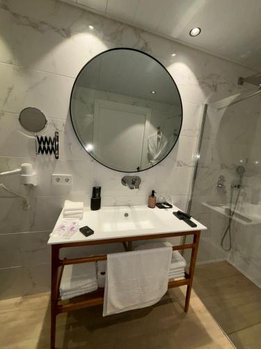 a bathroom with a sink and a mirror at Apartamentos Turísticos La Plaza in Chipiona