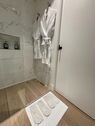 a bathroom with a shower and a door with a towel at Apartamentos Turísticos La Plaza in Chipiona
