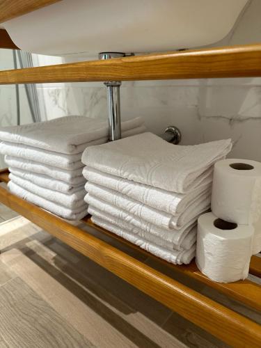a stack of towels and toilet paper on a shelf at Apartamentos Turísticos La Plaza in Chipiona