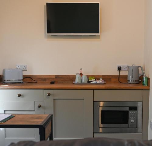 a kitchen with a counter with a tv on the wall at Wydon Farm Bed and Breakfast in Haltwhistle