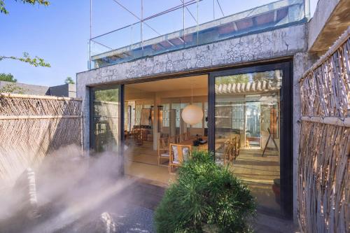 a house with sliding glass doors and a patio at Beijing Le Zai Nan Luo Gu Xiang Wang Fu Jing Forbidden City Courtyard Hotel&Free laundry service&Free coffee &Paid Dumpling experience service in Beijing