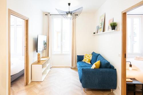 un salon avec un canapé bleu et un miroir dans l'établissement Meynadier Premium 2BR Refurb 2023 Olam Properties, à Cannes
