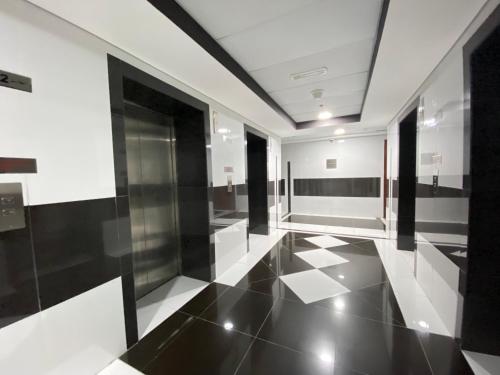 un pasillo con suelo y techo de baldosas blancas y negras en Sophisticated Living 2BR Gem in Dubai Gate Tower 2 - 22AB08, en Dubái