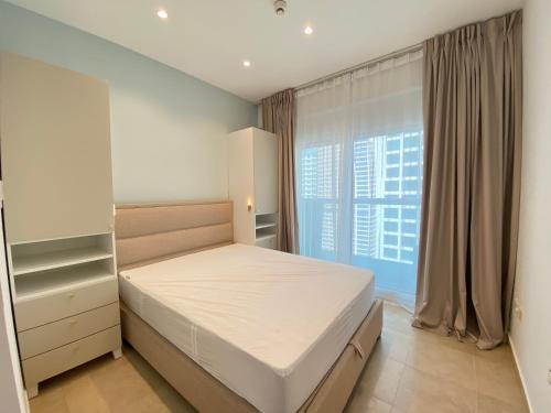 1 dormitorio con cama y ventana grande en Sophisticated Living 2BR Gem in Dubai Gate Tower 2 - 22AB08, en Dubái