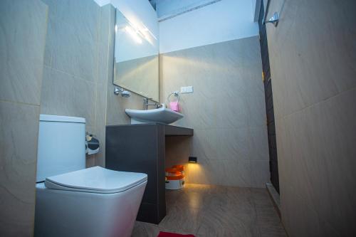 a bathroom with a white toilet and a sink at 209 Nooit Gedacht in Unawatuna