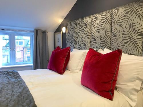 a bedroom with a bed with two red pillows at The Helaina in Scarborough