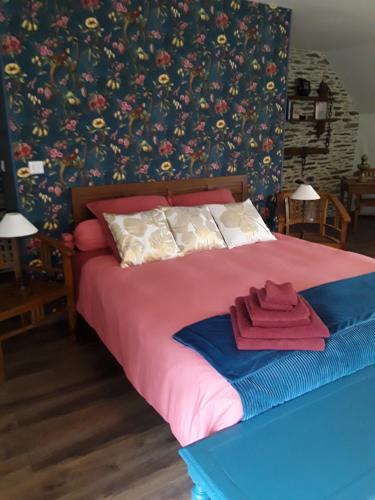 ein Schlafzimmer mit einem Bett mit roten Handtüchern darauf in der Unterkunft La petite seigneurie de Lourmel in Carentoir