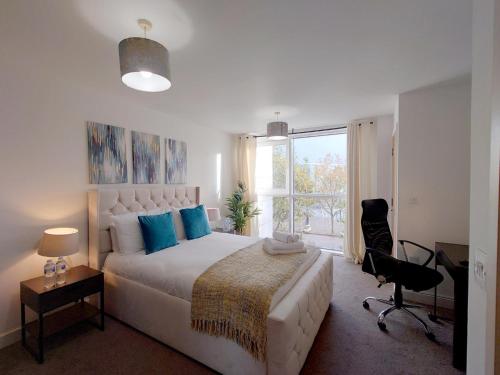 a bedroom with a bed and a desk and a window at Luxury Dockview 3 Beds Excel London in London