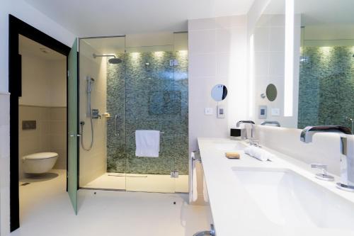 a bathroom with two sinks and a shower at Hilton Tangier Al Houara Resort & Spa in Al Houara