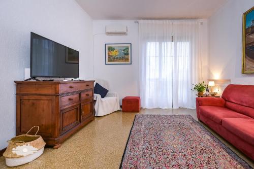 a living room with a red couch and a flat screen tv at La casa del marinaio in Genova
