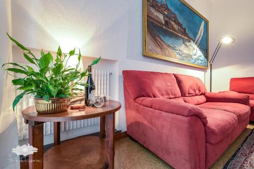 a living room with a red couch and a table at La casa del marinaio in Genova