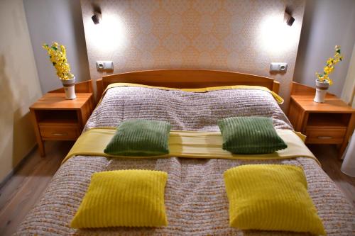 a bedroom with a bed with two green pillows at Comfortable 4-Room Apartments in Jekabpils in Jēkabpils