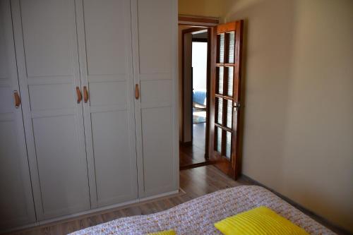a bedroom with white cabinets and a bed with a yellow pillow at Comfortable 4-Room Apartments in Jekabpils in Jēkabpils
