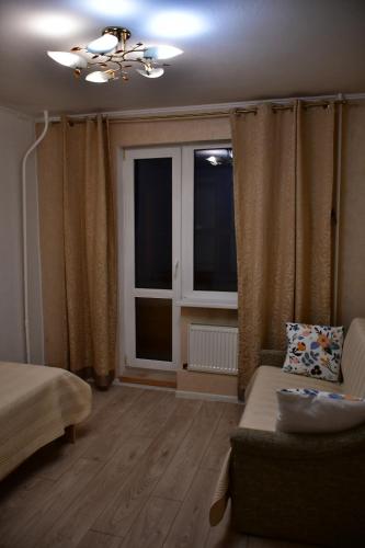 a living room with a couch and a window at Comfortable 4-Room Apartments in Jekabpils in Jēkabpils