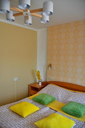 a bedroom with a bed with yellow and green pillows at Comfortable 4-Room Apartments in Jekabpils in Jēkabpils