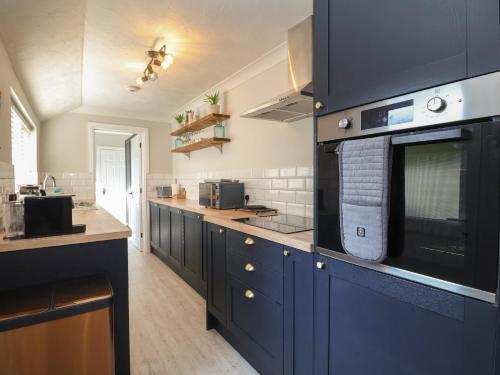 a kitchen with blue cabinets and a counter top at First Light in Lowestoft