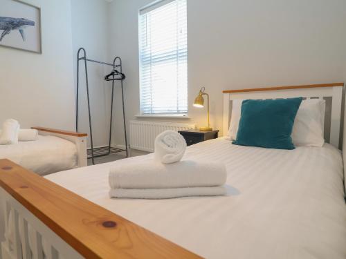 a bedroom with a bed with towels on it at First Light in Lowestoft