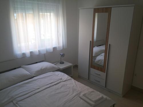 - une petite chambre avec un lit et un miroir dans l'établissement Apartments Rtina Benici, à Rtina
