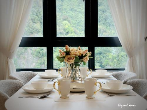 a table with a vase of flowers on it at Sunway Onsen Suite Theme Park View Top Floor at Lost World in Tambun